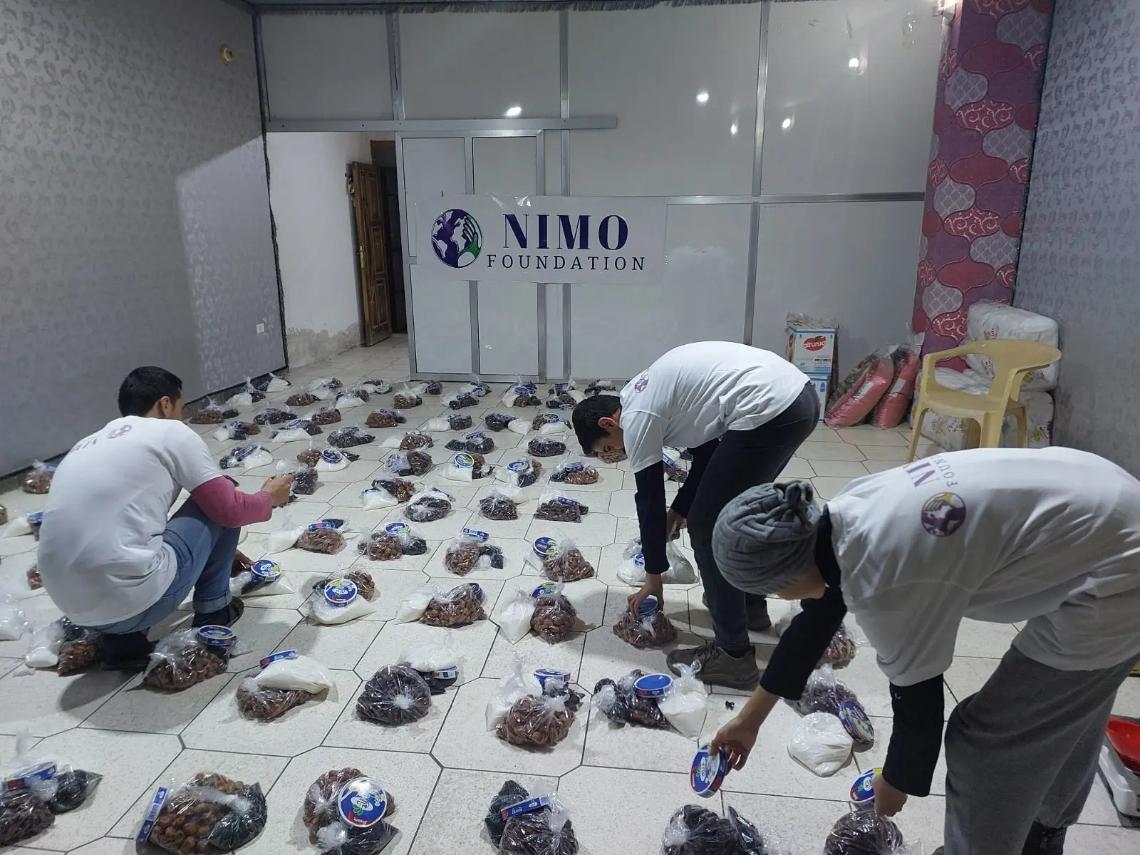 Freiwillige der Nimo Foundation packen Lebensmittelpakete
